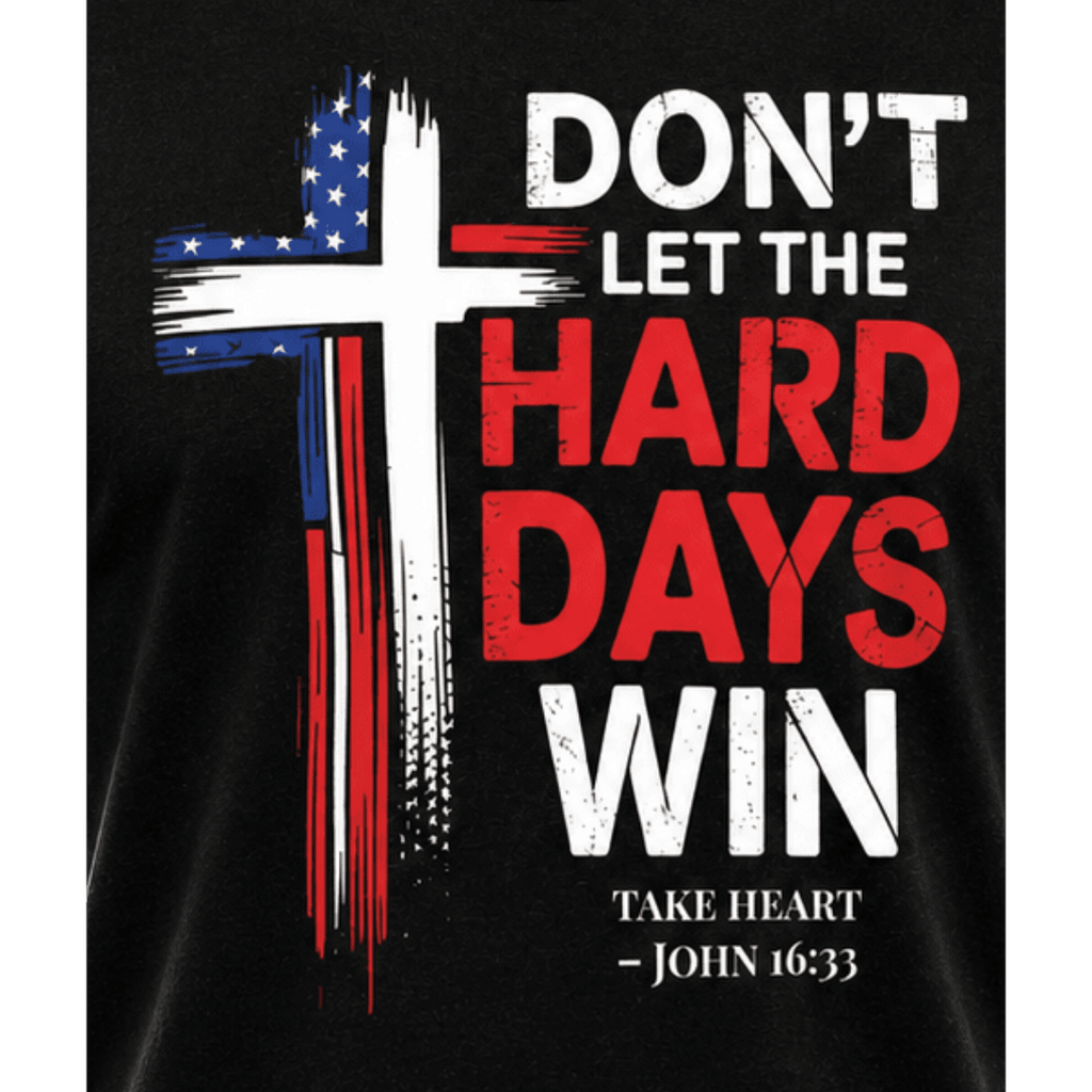 Close-up of patriotic cross graphic on black Don't Let the Hard Days Win Tee Christian t-shirt featuring John 16:33 scripture reference