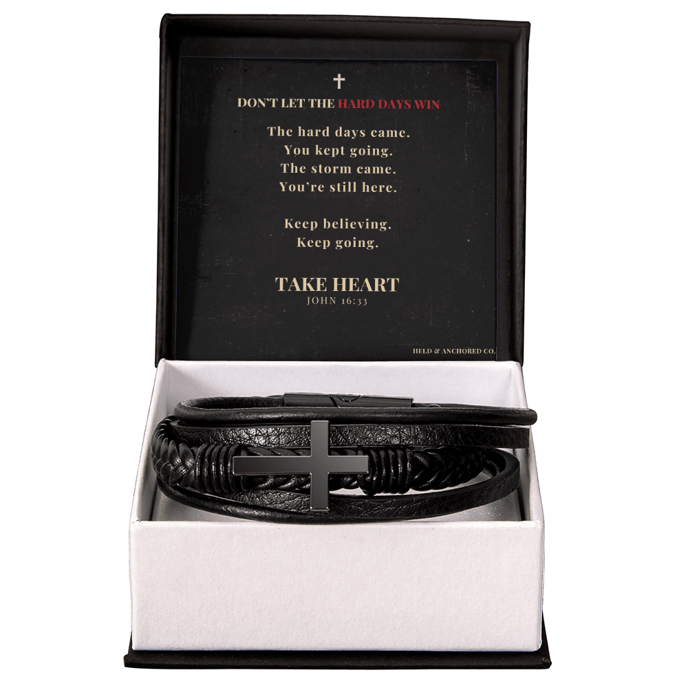 Black leather men's cross bracelet displayed in a gift box with an inspirational "Don't Let the Hard Days Win" message card.