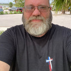 Shane, founder of Held & Anchored, wearing the Don't Let the Hard Days Win Tee — patriotic cross front design in Black Heather