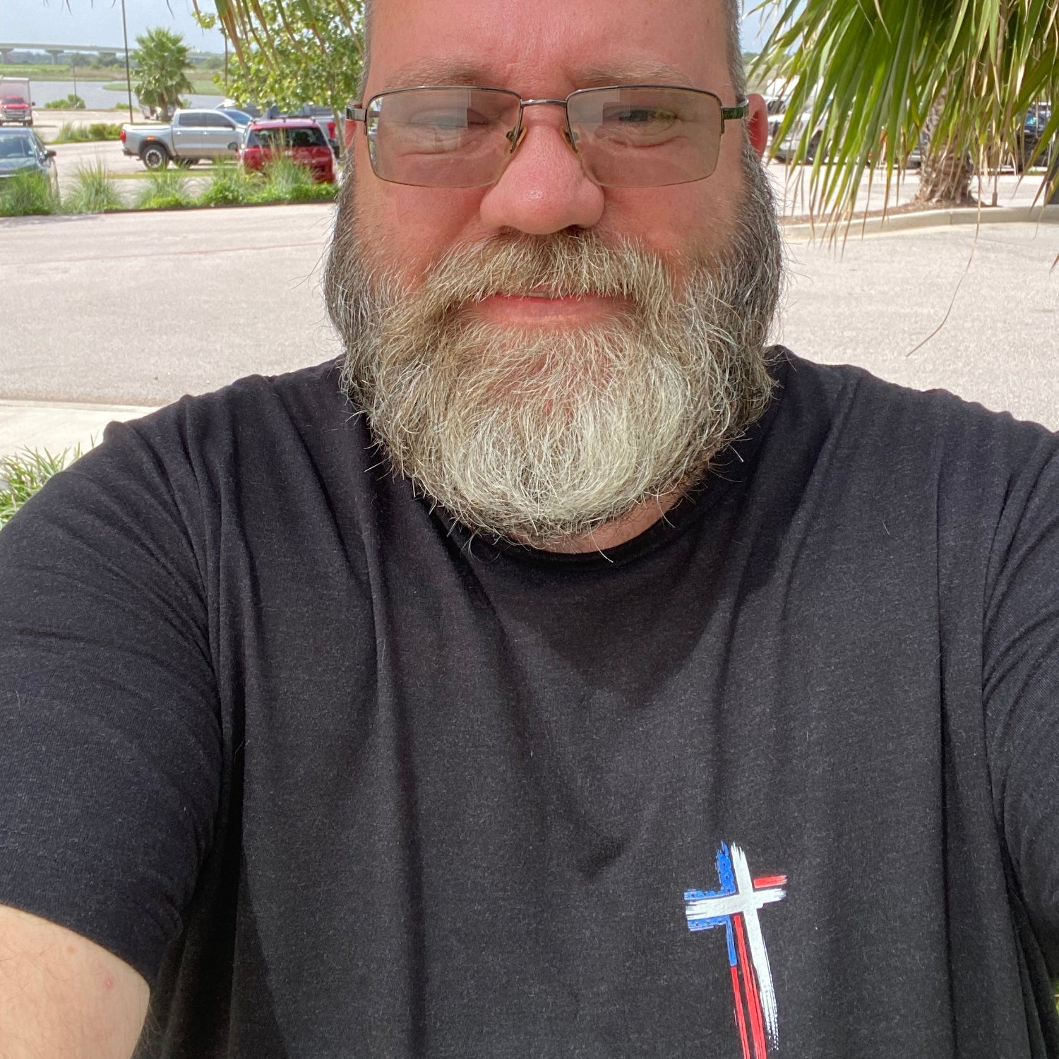 Shane, founder of Held & Anchored, wearing the Don't Let the Hard Days Win Tee — patriotic cross front design in Black Heather