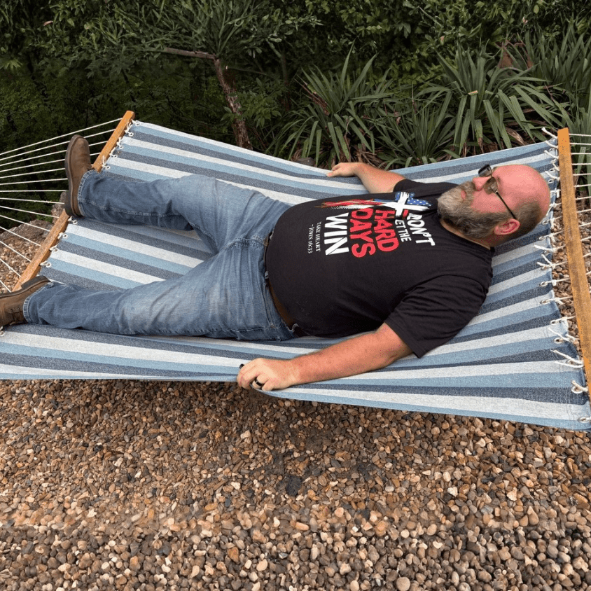 Shane, founder of Held & Anchored, wearing the Don't Let the Hard Days Win Tee outdoors — the shirt this brand was built on