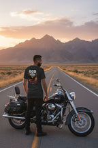 Man standing next to a motorcycle on a road with mountains in the background