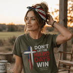 Woman wearing a patriotic "Take Heart – John 16:33" bandana as a head wrap and a Military Green "Don't Let the Hard Days Win" Christian t-shirt while relaxing on a rustic porch at sunset, reflecting faith, strength, and encouragement through life's challenges.