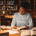 Still Becoming Crewneck Sweatshirt worn by a young woman studying for an exam.  